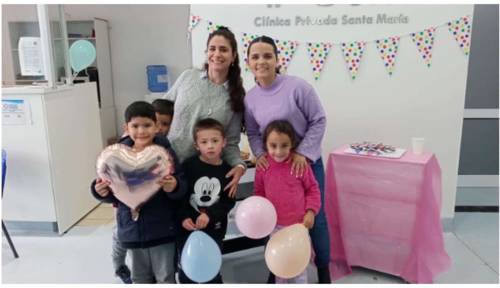 Fonoaudióloga y pediatra de la clínica con cuatro chicos y globos, en el taller de lectura del Mes de las Infancias